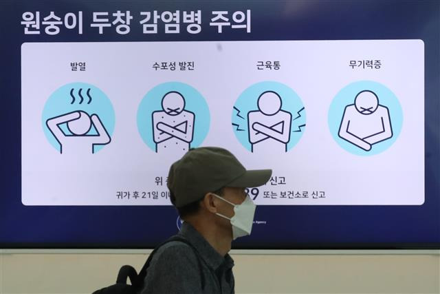 질병청, “원숭이두창 대유행 가능성 없다” - 5일 인천국제공항 제1여객터미널 출국장 전광판에 표시된 원숭이두창 감염병 주의 안내문 앞을 한 시민이 지나가고 있다.  뉴스1