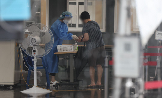 지난달 30일 오전 서울역 광장에 마련된 코로나19 임시 선별검사소에서 의료진이 안내를 하고 있다. <연합뉴스>