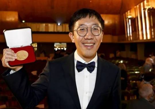 Recognized by the World: Dr. June Huh, a professor at Princeton University and a distinguished professor of mathematics at the Korea Institute for Advanced Study, raises the medal after receiving the Fields Medal at the International Mathematical Union (IMU) Award Ceremony held at the Aalto University in Helsinki, Finland on July 5 (local time). Helsinki / AP-Yonhap News
