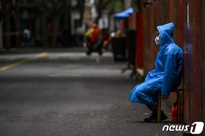 코로나19 재봉쇄령이 내려진 중국 상하이 주거 지역에 세워진 펜스 앞에서 방역요원이 지키고 있다. © AFP=뉴스1 © News1 우동명 기자