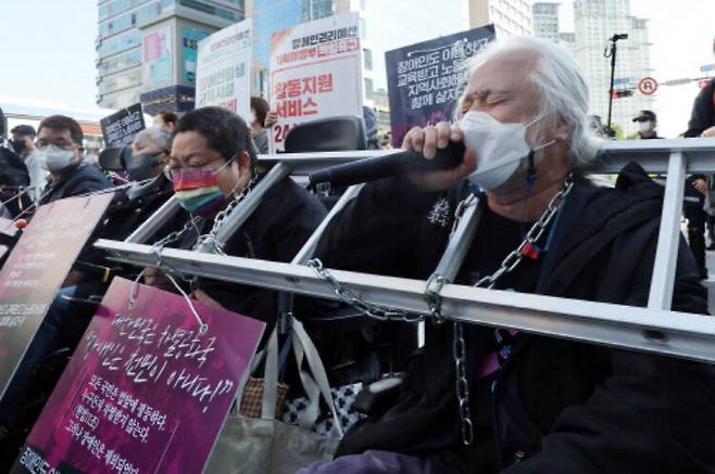 전국장애인차별철폐연대(전장연) 박경석 상임 공동 상임 대표(오른쪽) 등 회원들이 지난 5월16일 출근 시간대에 서울 신용산역 인근에서 대통령실로 향하는 한강대로 횡단보도를 점거한 채 장애인 권리예산 보장 등을 요구하는 시위를 하고 있다. 연합뉴스