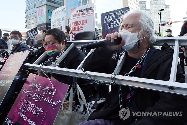 장애인 권리 예산 보장 요구 전국장애인차별철폐연대(전장연) 박경석 상임공동대표(오른쪽) 등 장애인들이 지난 5월 16일 출근 시간대에 서울 신용산역에서 대통령실로 향하는 한강대로의 횡단보도를 점거한 채 장애인 권리 예산 보장 등을 요구하는 시위를 하는 모습 [연합뉴스 자료사진]