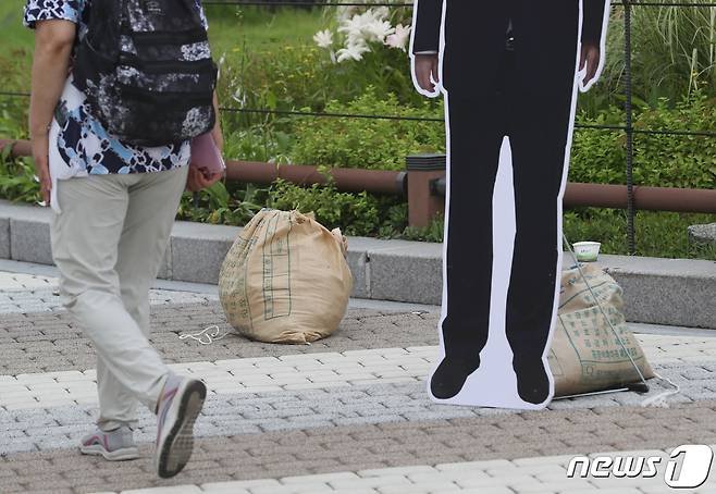 8일 오후 서울 종로구 청와대 분수대 앞 윤석열 대통령과 김건희 여사의 등신대가 있던 자리에 모래 주머니만 남아 있다. 신자유연대 관계자는 "한 열성팬이 등신대와 함께 사진을 찍다가 부러져서 할 수 없이 치웠다＂고 밝혔다. 2022.7.8/뉴스1 © News1 이성철 기자