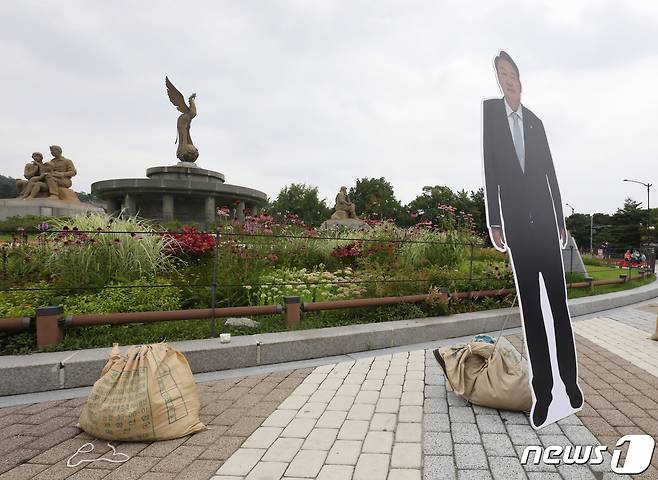 8일 오후 서울 종로구 청와대 분수대 앞 윤석열 대통령과 김건희 여사의 등신대가 있던 자리에 모래 주머니만 남아 있다. 신자유연대 관계자는 "한 열성팬이 등신대와 함께 사진을 찍다가 부러져서 할 수 없이 치웠다＂고 밝혔다. 2022.7.8/뉴스1 © News1 이성철 기자