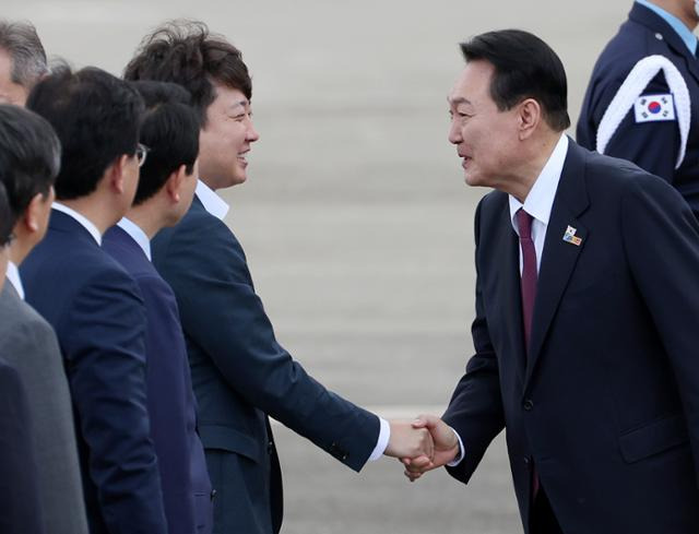 윤석열 대통령이 1일 북대서양조약기구(NATO·나토) 정상회의 참석을 마치고 성남 서울공항에 도착, 국민의힘 이준석(왼쪽) 대표와 악수하고 있다. 대통령실 제공