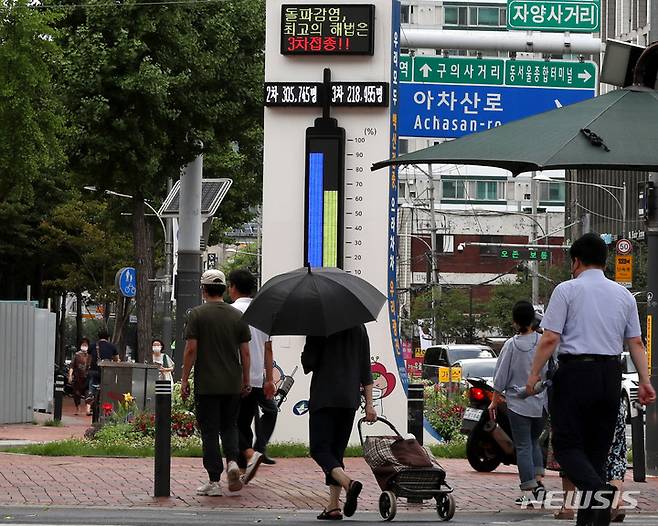 [서울=뉴시스] 추상철 기자 = 지난 7일 오후 서울 광진구 자양사거리에서 시민들이 백신접종 현황판 앞을 지나고 있다. 2022.07.07. scchoo@newsis.com