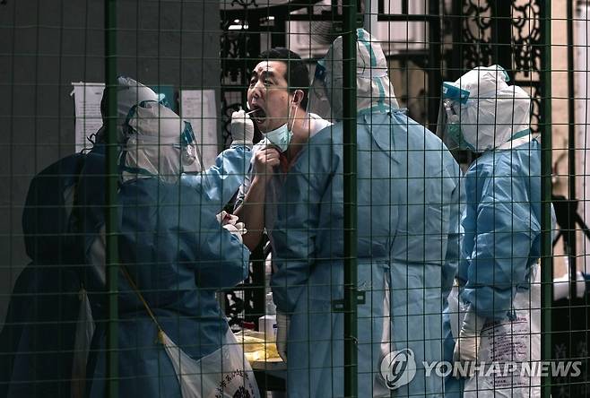 (EPA=연합뉴스) 지난 6월 21일 중국 상하이의 격리 구역에서 한 주민이 코로나19 검사를 받는 모습. 2022.7.8.