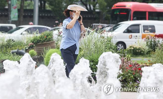 부채로 가려보는 땡볕 서울 한낮 기온이 30도를 넘기며 폭염이 이어진 6일 한 시민이 서울 중구 서울광장 분수대에서 부채로 햇빛을 가리고 있다. [연합뉴스 자료사진]