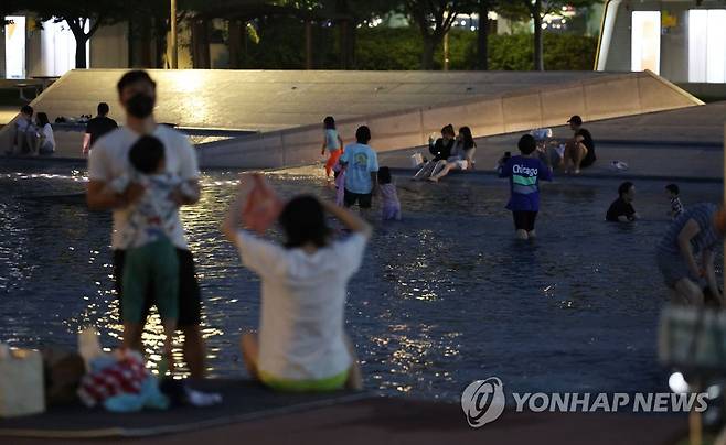 지난 5일 오후 서울 영등포구 여의도한강공원 물빛광장분수대를 찾은 시민들이 더위를 식히고 있다. [연합뉴스 자료사진]