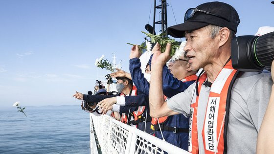 서해에서 북한군에 의해 피살된 해양수산부 공무원의 형 이래진 씨(오른쪽)를 바롯한 참석자들이 지난 2일 국가어업지도선 무궁화 35호에 올라 연평도 인근 사고 현장 주변 해역을 지나며 선상에서 열린 위령제에서 바다를 향해 헌화하고 있다. [뉴스1]