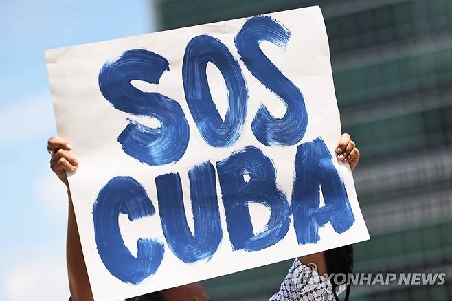 2021년 7월 14일 뉴욕 유엔본부 앞 시위자가 들고 있는 'SOS CUBA' 팻말  [AFP 연합뉴스 자료사진. 재판매 및 DB 금지]