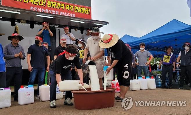 원유 쏟아버리는 낙농민들 (홍성=연합뉴스) 조성민 기자 = 낙농협회 충남도지회에 속한 낙농민들이 11일 충남도청 앞에서 열린 '낙농 말살 정부·유업체 규탄' 궐기대회에서 원유를 쏟아버리고 있다. 2022.7.11 min365@yna.co.kr