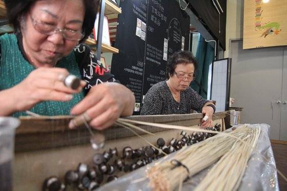 1980년대까지만 해도 강화도에서는 가내수공업으로 화문석을 많이 만들었다. 지금은 60대 이상 장인 일부만이 남아 명맥을 잇고 있다. 장인들이 고드랫돌로 화문석을 짜는 모습. 사진 강화도령 화문석