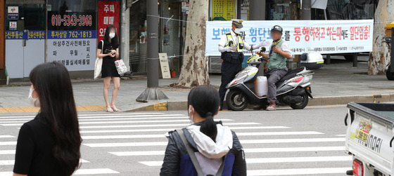 횡단보도 앞 일시정지 등 보행자 보호 의무를 강화한 도로교통법 개정안 시행 첫날인 12일 서울 종로구 이화사거리에서 경찰들이 계도에 나서고 있다. /사진=뉴스1