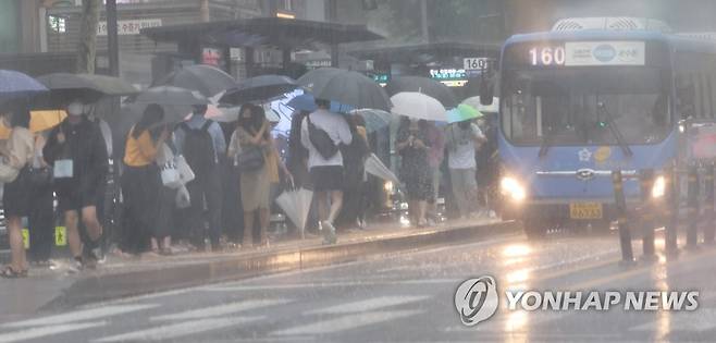 우중퇴근 (서울=연합뉴스) 한상균 기자 = 13일 퇴근 시간. 서울 시내 정류장에서 시민들이 비를 피하며 버스를 기다리고 있다. 2022.7.13 xyz@yna.co.kr