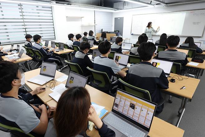 13일 서울시내 한 중학교에서 학생들과 선생님이 마스크를 착용하고 수업을 하고 있다. 코로나19 유행이 증가세를 보이면서 최근 1주간 전국 학생 확진자가 직전 주의 2.5배로 증가해 2만 명을 넘었다. 연합뉴스