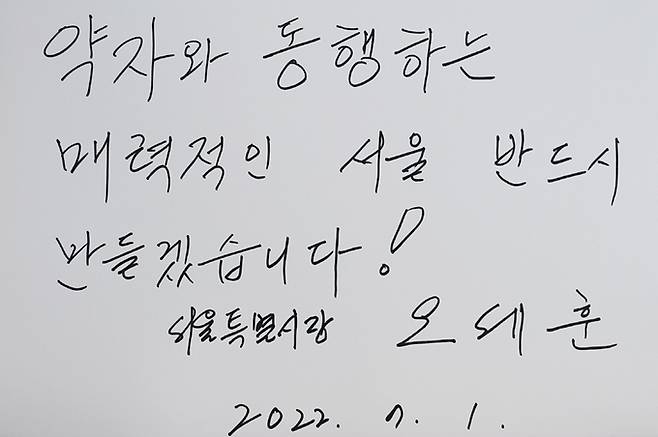 오세훈 서울시장이 지난 1일 서울 동작구 국립서울현충원을 찾아 현충탑에서 참배를 마친 뒤 작성한 방명록을 현충원 관계자가 보여주고 있다. 연합뉴스