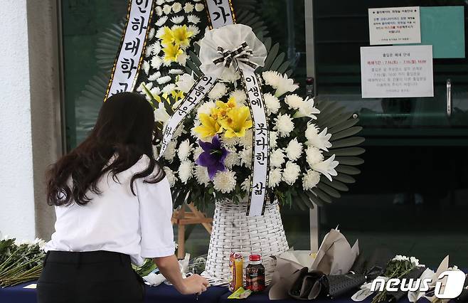 인하대학교 캠퍼스에서 같은 학교 재학생을 성폭행한 뒤 건물에서 추락해 숨지게 한 사건이 발생한 가운데 17일 오전 인천광역시 인하로 인하대학교에 마련된 추모공간에서 한 학생이 추모를 하고 있다. 2022.7.17/뉴스1 © News1 임세영 기자