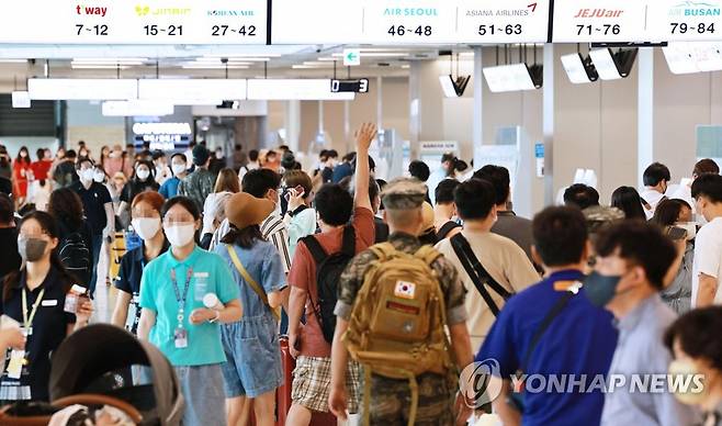 코로나19 확산세 속 붐비는 공항 (서울=연합뉴스) 한종찬 기자 = 코로나19 확산세가 거세지는 가운데 15일 오전 서울 강서구 김포공항 국내선 청사에서 이용객들이 탑승 수속을 밟고 있다. 2022.7.15 saba@yna.co.kr