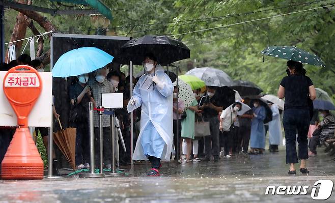 18일 오전 장맛비가 강하게 내리는 대구 달서구보건소 선별진료소에서 시민들이 줄지어 코로나19 검사를 기다리고 있다. 이날 대구에서 1022명이 코로나19 확진 판정을 받아 휴일 확진자 발생 수로는 지난 4월25일 1422명 이후 12주 만에 최대 규모다. 2022.7.18/뉴스1 © News1 공정식 기자