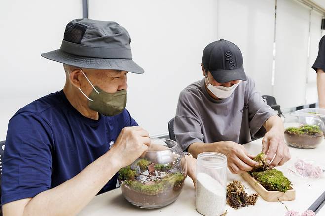 서울 마포구 서교동주민센터에서 지난 12일 열린 고시원 1인 가구의 ‘테라리움’ 만들기 수업에서 주민들이 각자의 어항에 작은 정원을 만들고 있다. 마포구 제공