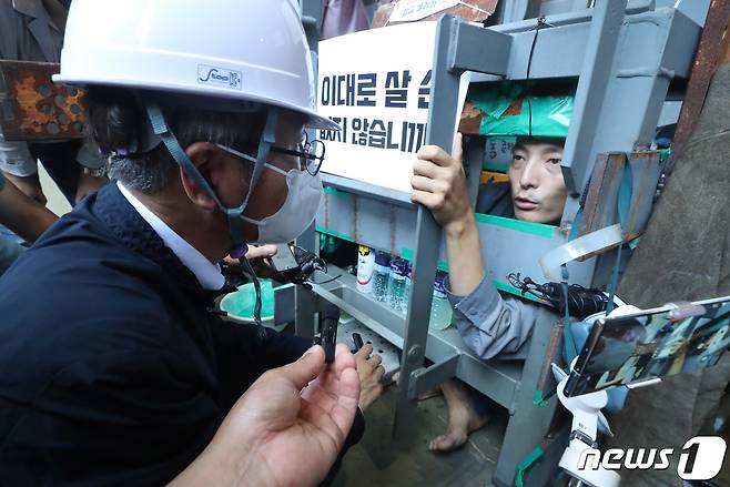 이정식 고용노동부 장관이 19일 경남 거제 거제·통영·고성 조선하청지회 조합원 점거 농성 중인 대우조선해양 1도크를 찾아 유최안 대우조선 하청지회 부지부장과 대화를 나누고 있다. (공동취재) 2022.7.19/뉴스1 © News1 김영훈 기자