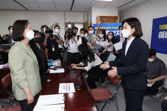 박지현 전 더불어민주당 공동비상대책위원장(오른쪽)이  18일 오전 국회 의원회관에 마련된 더불어민주당 당대표 및 최고위원 예비후보 등록 신청 접수처에서 중앙당 관계자에게 ‘당대표 선거 (예비)후보자 등록 서류’를 내밀고 있다. 접수처 관계자는 “제출한 등록 서류는 자격 미달로 당 규정에 따라 접수 자체가 안된다”며 접수를 거부했다. 2022. 7. 18 김명국 기자