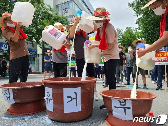 ㈔한국낙농육우협회 충북지회가 19일 충북도청 정문 앞에서 원유 용도별 차등 가격제 폐지를 요구하는 집회를 한 뒤 집유 거부 퍼포먼스를 하고 있다.2022.7.19/© 뉴스1 엄기찬 기자