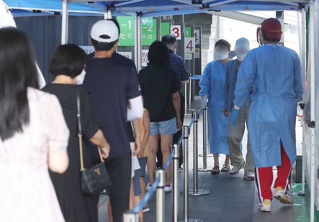 국내 신종코로나바이러스 감염증(코로나19) 신규 확진자가 7만6402명을 기록한 20일 서울 용산구보건소 선별진료소를 찾은 시민들이 검사 대기를 하고 있다. /뉴스1