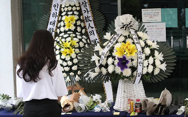 성폭행을 당한 뒤 학교 건물에서 추락해 숨진 피해 여대생을 추모하기 위해 인하대 캠퍼스에 마련된 추모공간에서 한 학생이 묵념을 하고 있다. /뉴스1