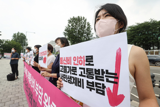 19일 서울 용산구 대통령집무실 인근에서 열린 고물가 가계통신비 부담 완화 대책 촉구 기자회견에서 한 참가자가 팻말을 들고 있다. 연합뉴스