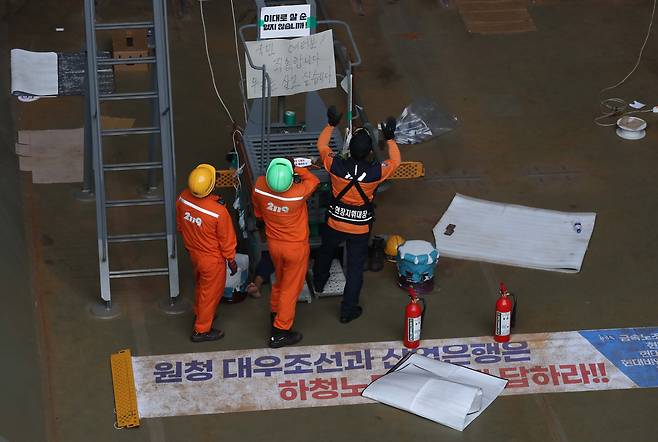 대우조선해양 하청 노사협상이 극적으로 타결된 22일 오후 경남 거제시 아주동 대우조선해양 옥포조선소 내 1독에서 대우조선 소방대원이 철 구조물에서 농성 중인 유최안 금속노조 거제통영고성 조선하청지회 부지회장을 살펴보고 있다. /연합뉴스