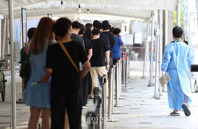 코로나19 신규 확진자가 7만3582명으로 집계된 19일 서울 코로나19 마포보건소 선별진료소 앞에서 시민들이 코로나19 검사를 받기 위해 줄지어 서 있다.ⓒ데일리안 김민호 기자