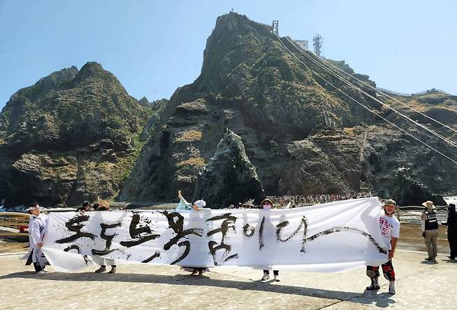 [포항=뉴시스] 강진구 기자 = 독도 사랑 예술인 연합회 김지영 회장과 전통 춤꾼 김옥순 선생, 쌍산 김동욱 서예가는 2일 오전 독도 현지에서 3인 합동 공연을 실시했다. 김지영 회장은 '독도에 무궁화 꽃이 피었습니다'라는 글을 대형 붓으로 쓰고 태극기를 든 김옥순 선생은 봉황 춤을 추며 독도 평화를 기원했다. 김동욱 서예가는 '독도는 목숨이다'를 쓰며 목숨을 바쳐 지킨다는 의지를 표현했다.(사진=쌍산 김동욱 선생 제공) *재판매 및 DB 금지