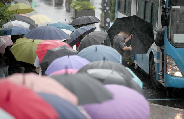 호우주의보가 발효된 18일 부산 금정구 부산대역 버스정류장에 우산 쓴 시민들이 버스를 타려고 줄 서고 있다. 뉴스1