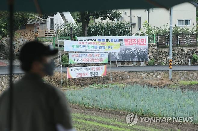 사저 앞 현수막 호소 지난 7월 14일 낮 경남 양산시 하북면 지산리 평산마을 문재인 전 대통령 사저 앞에 '우리들의 평화와 일상을 돌려주세요' '욕설은 자제해주세요. 평화적인 집회를 원합니다' 등이 적힌 현수막이 걸려 있는 가운데 경호처 직원이 사저 경비를 서고 있다. [연합뉴스 자료사진]