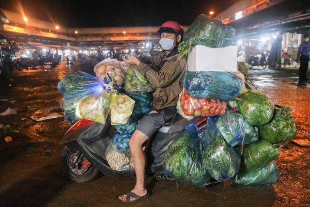 베트남 호찌민시의 한 야채 도매상이 비닐봉지에 물건을 담아 이동하고 있다. VN익스프레스 캡처
