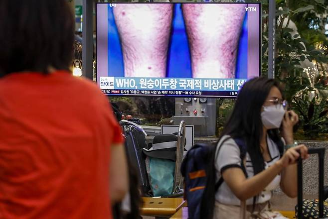 [인천공항=뉴시스] 정병혁 기자 = 세계보건기구(WHO)가 세계 전역에서 발병한 원숭이두창에 대해 '국제적으로 우려되는 공중보건상 비상사태(PHEIC)'를 선언한 24일 오전 인천국제공항 1터미널 입국장에서 시민들이 TV를 통해 관련 뉴스를 시청하고 있다. 2022.07.24.