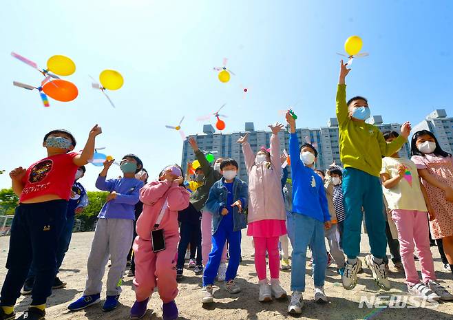 [서울=뉴시스] 김종택기자 = 과학의 날을 하루 앞둔 지난 4월20일 경기도 수원시 영통구 효원초등학교 운동장에서 1학년 학생들이 풍선 헬리콥터를 만들어 날리고 있다. 2022.07.25. jtk@newsis.com