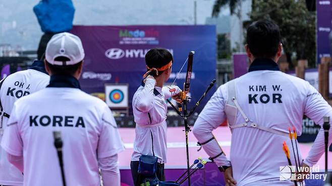 활 쏘는 김제덕과 지켜보는 김우진(오른쪽)