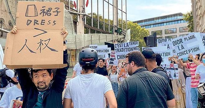 지난 23일 프랑스 파리에서 열린 디올의 중국 문화 표절 항의 시위. 사진 맨 왼쪽 시위자는 '치마가 인권보다 중요하냐'며 맞불 항의 시위를 펼쳤다. [홍콩 명보 캡처. 재판매 및 DB 금지]