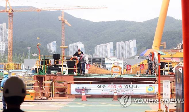 진수 작업 중입니다 (거제=연합뉴스) 김동민 기자 = 25일 경남 거제시 아주동 대우조선해양 옥포조선소에서 작업자가 진수 작업 현장을 통제하고 있다. 사진 왼쪽이 하청지회 노조가 농성을 벌이던 독이 있던 자리다. 현재 농성했던 선박은 다른 곳으로 이동했다. 2022.7.25 image@yna.co.kr