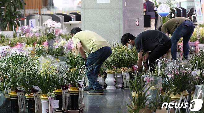 후반기 국회 원 구성 협상 타결 뒤 여야의원들의 상임위원회 배정도 마무리되고 있는 가운데 26일 오후 국회 의원회관 민원실 앞에 상임위원회와 관련된 단체가 의원들에게 보내온 축하 난을 사무처 직원들이 정리하고 있다.  (공동취재) 2022.7.26/뉴스1 © News1 허경 기자