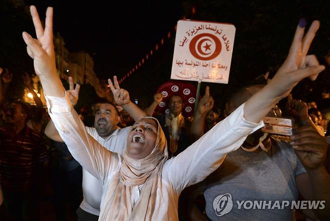 개헌 국민투표 출구조사 결과에 환호하는 카이스 사이에드 대통령 지지자들. [AFP 연합뉴스 자료사진. 재판매 및 DB 금지]