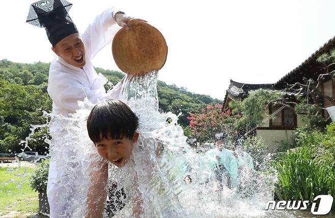 중복인 26일 전국에 폭염주의보가 내려진 가운데 충남 논산시 연산면 양지서당 '양지농촌유학센터'에서 공부하는 어린이들이 훈장 선생님의 등목으로 더위를 식히고 있다. 2022.7.26/뉴스1 © News1 김기남 기자