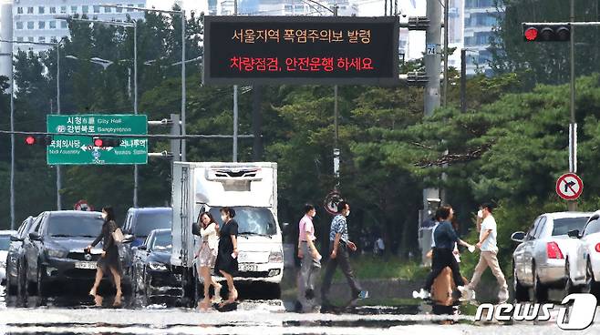 삼복더위의 두 번째 '중복'인 26일 오후 서울 여의도공원 앞 횡단보도에 아지랑이가 피어오르고 있다. 동해안을 제외한 전국 대부분으로 '폭염특보'가 내려진 가운데 서울 낮 기온 33도, 대구는 34도까지 치솟으며 무더위가 계속될 전망이다. 2022.7.26/뉴스1 © News1 임세영 기자