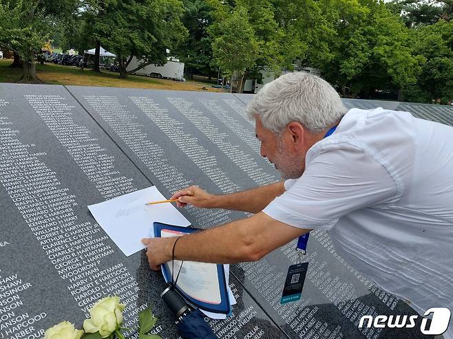 한국전 전사자의 유가족으로 보이는 한 남성이 26일(현지시간) 미국 워싱턴DC 한국전 참전용사 기념공원내에 건립된 '추모의 벽'에 새겨진 잊혀진 영웅의 이름에 대해 탁본을 뜨고 있다. © 뉴스1