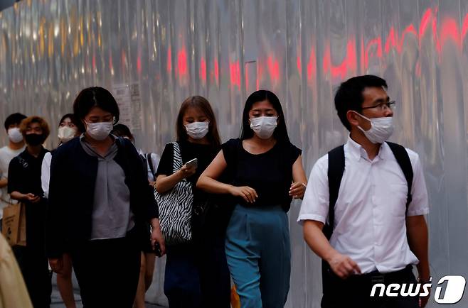 일본 도쿄에서 25일(현지시간) 마스크를 쓴 시민들이 거리를 걷고 있다. © 로이터=뉴스1 © News1 김민수 기자