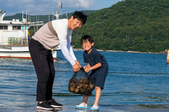 충남 보령 학성2리의 대표 놀거리는 통발 체험이다. 최대성 마을 이장과 어린이 체험객이 통발로 거둬들인 소라 꾸러미를 들어 보이고 있다.