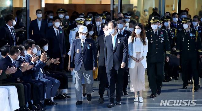 [서울=뉴시스] 조수정 기자 = 한덕수(가운데) 국무총리가 27일 오전 서울 중구 동대문디자인플라자(DDP)에서 열린 '6·25 전쟁 유엔군 참전의 날' 기념식에서 유엔참전용사 후손인 튀르키예(터키) 출신 국내 교환학생 일라이다 아심길(한총리 오른쪽) 씨와 입장하고 있다. 2022.07.27. chocrystal@newsis.com